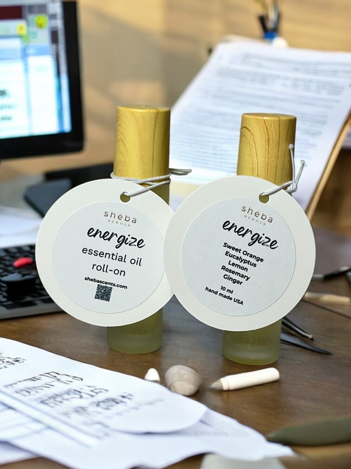 10 ml Sheba Scents Energize Essential Oil Roll-On with clean, white frosted glass bottle with fresh citrus, eucalyptus, and rosemary accents.