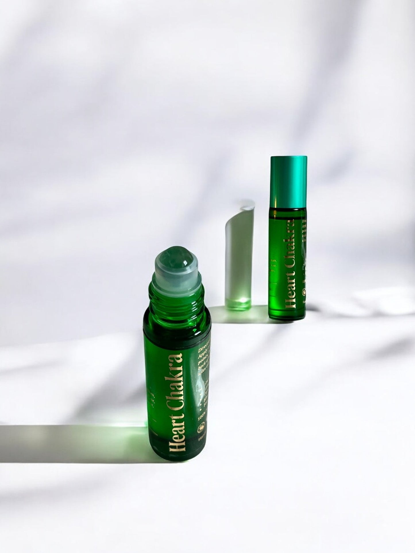 Sheba Scents Heart Chakra Essential Oil Roll-On with green heart chakra bottle and green aventurine crystal roller ball for love, balance, and emotional healing.