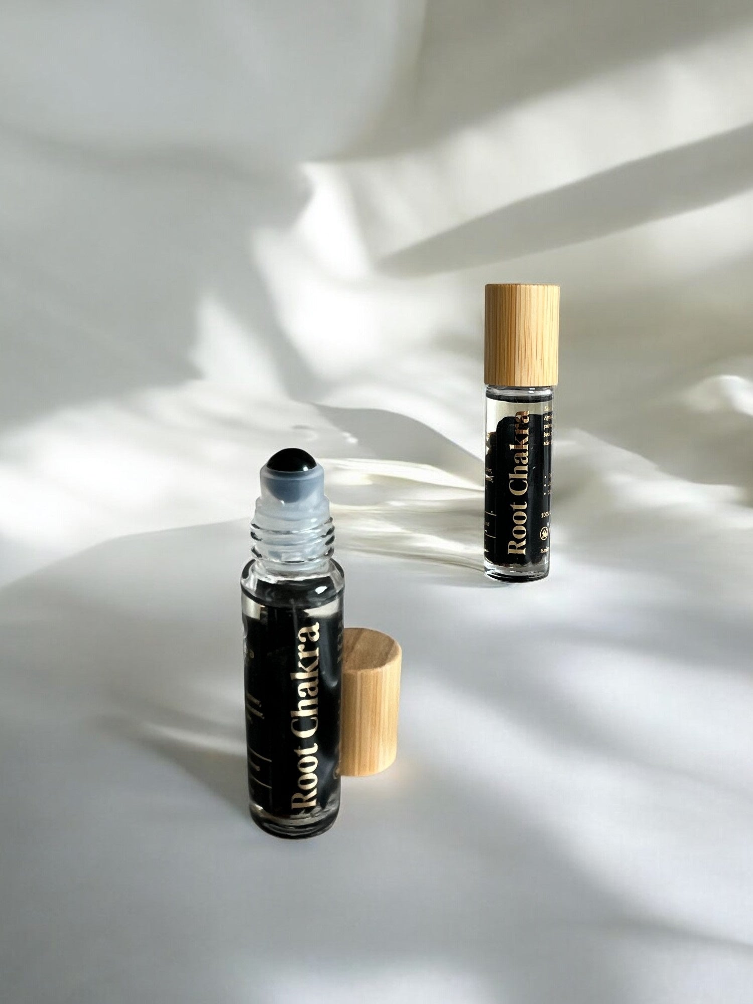 Sheba Scents Root Chakra Essential Oil Roll-On with black obsidian crystals ideal for meditation, reiki, yoga, grounding, and spiritual healing.