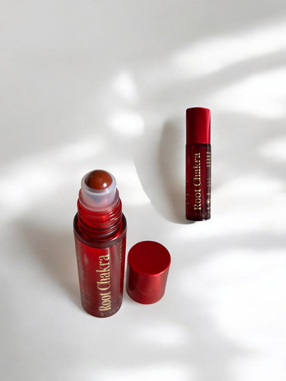 Sheba Scents Root Chakra Essential Oil Roll-On with red glass bottle and red jasper roller ball, infused with vetiver, myrrh, frankincense, grapefruit, and pine for grounding and stability.