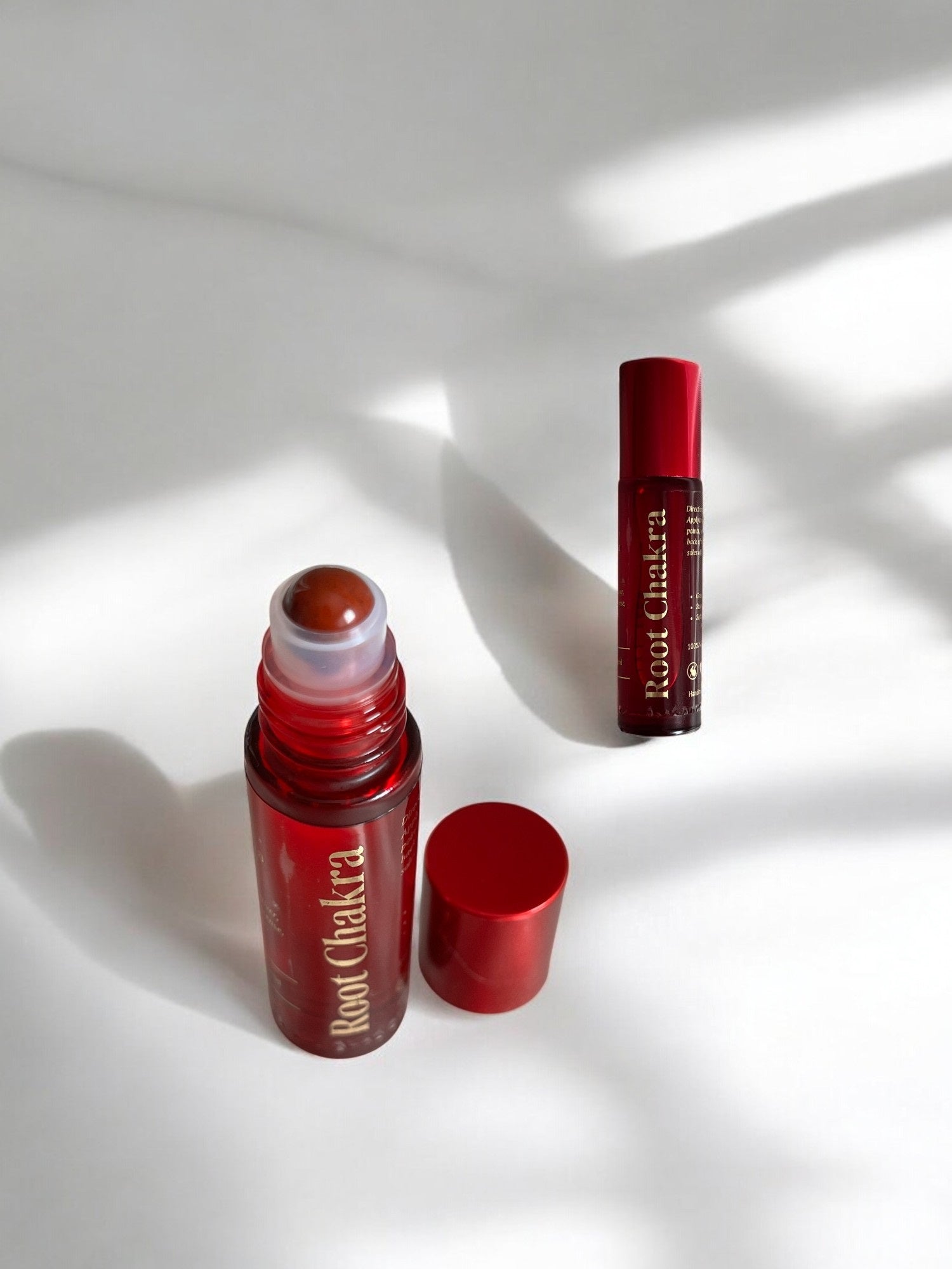 Sheba Scents Root Chakra Essential Oil Roll-On being applied to pulse points for emotional balance, grounding, and stability.