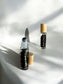 Sheba Scents Root Chakra Roll-On featuring black obsidian crystal filled bottle designed to support grounding, emotional stability, and root chakra healing.