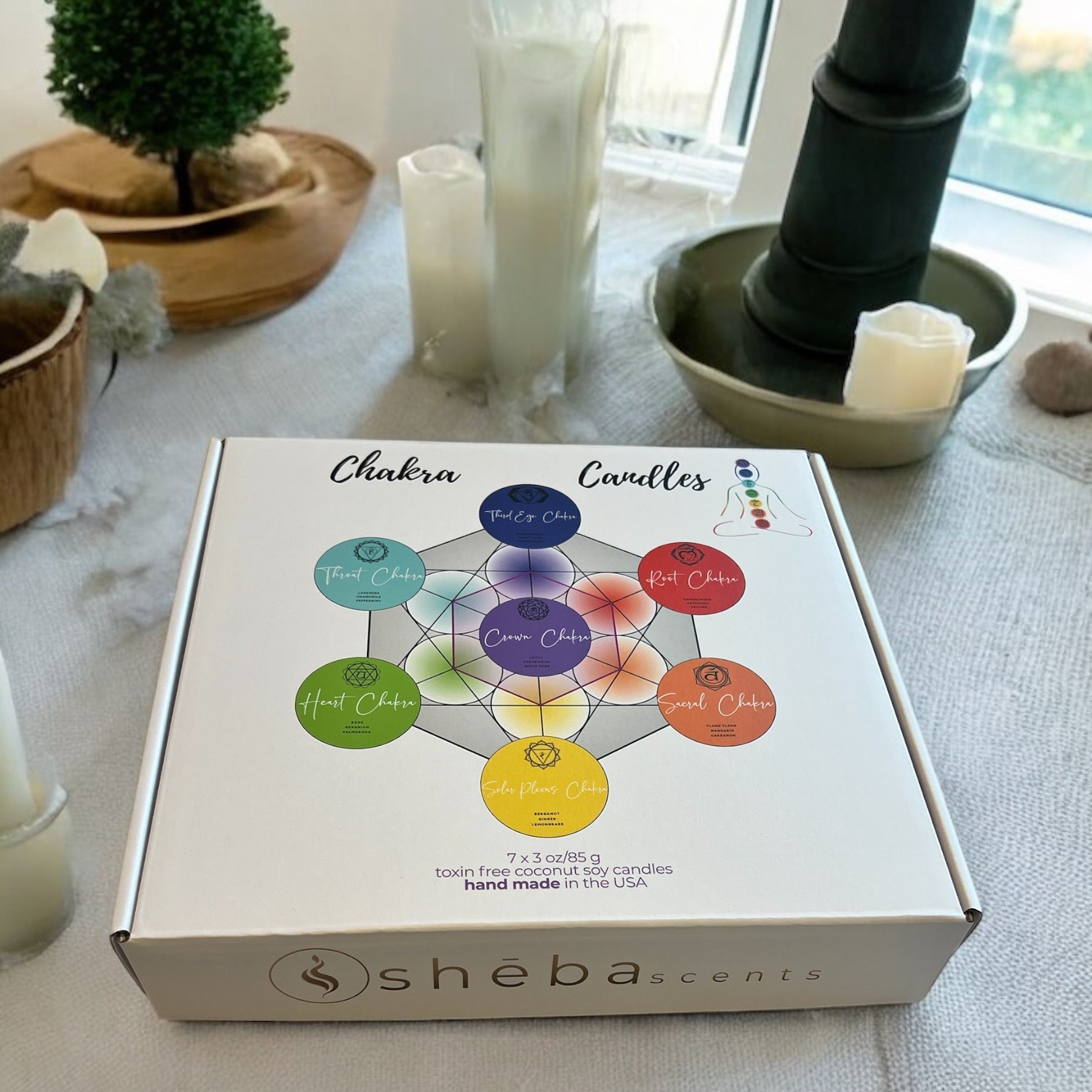 Set of seven Sheba Scents chakra candles in frosted glass jars, each one is reiki-infused, chakra specific colored jars, and made with an original aromatherapy blend